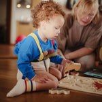 Mushie natural wooden shape puzzle for baby development.