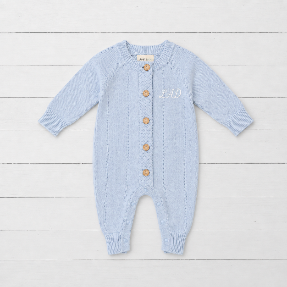 Powder blue pointelle knit baby romper with front buttons, long sleeves and ribbed cuffs