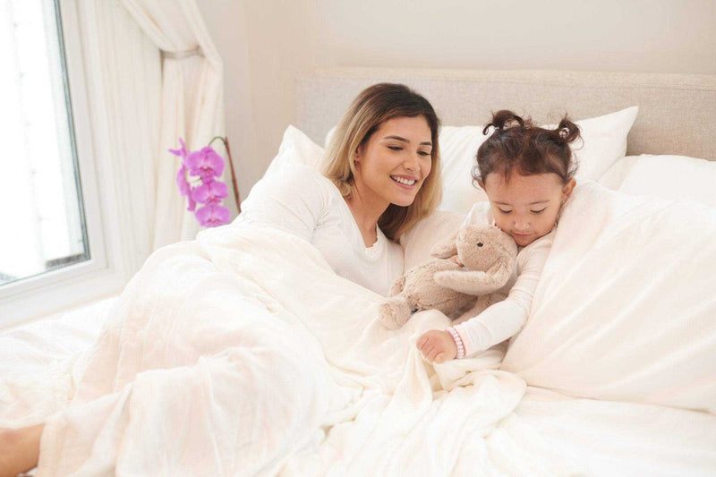 Pristine White Blanket bamboo bed blanket on bed with mother and child.