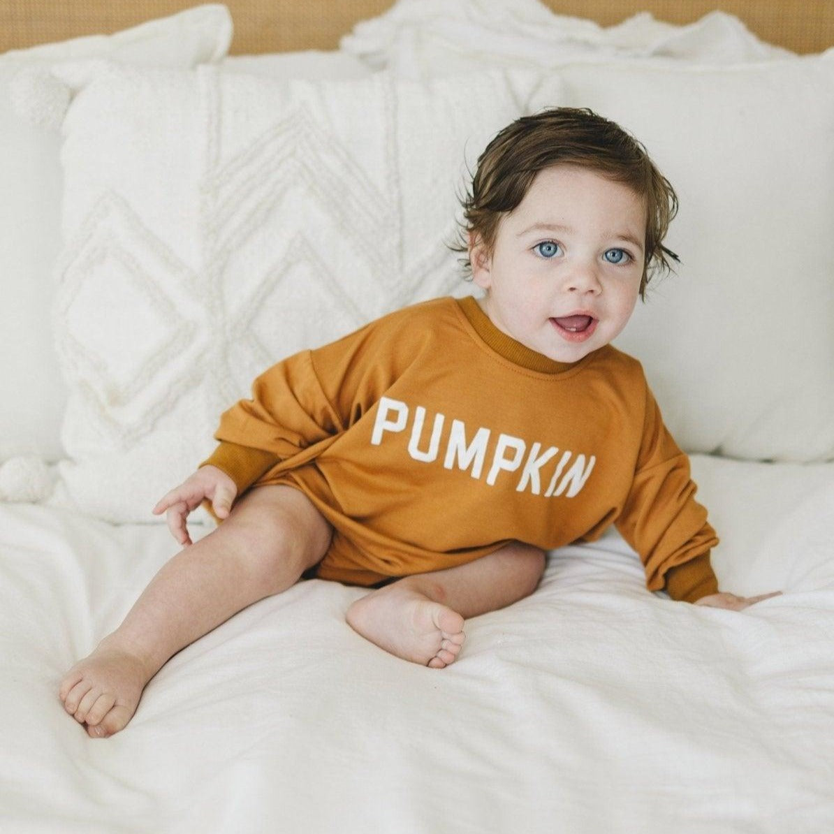 Pumpkin-colored bamboo bubble romper for babies with snaps at the crotch