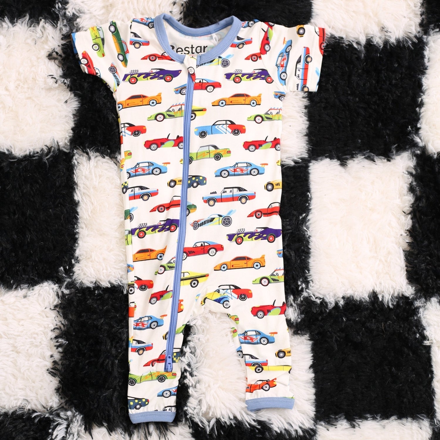 Baby coverall with a whimsical racing cars print, long sleeves, fold-over feet, and a full-length front zipper