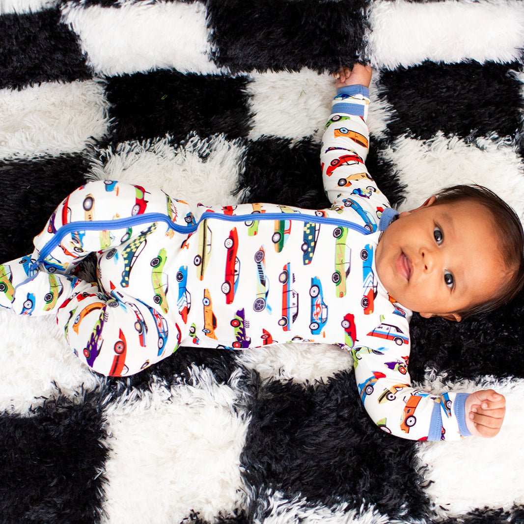 Baby footie pajamas with an all-over colorful race car print and a full-length two-way zipper.