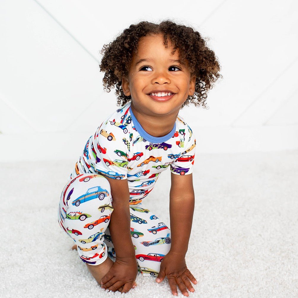 Short sleeve baby pajama set with an allover race car print on a light background.