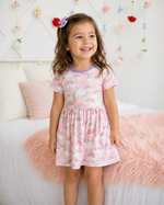 Short sleeve bamboo dress with a rainbow print, shown on a plain background