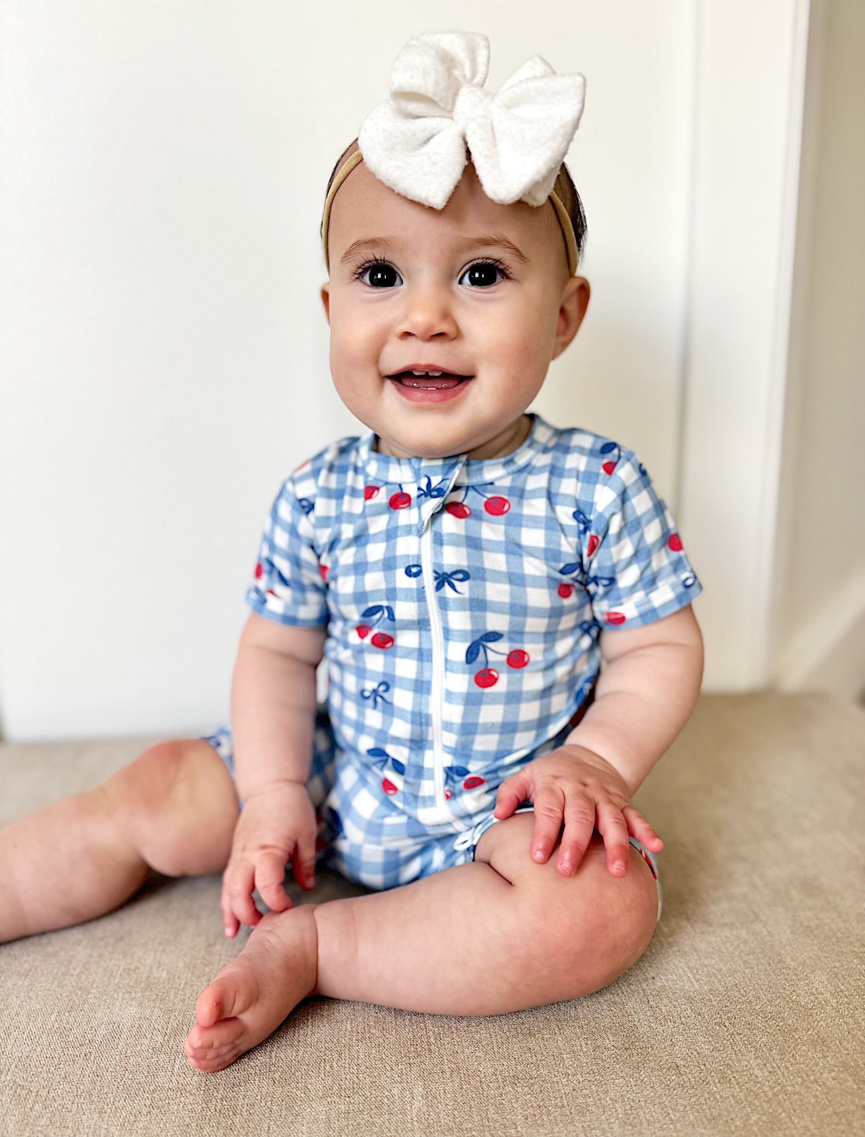 Toddler wearing Red, White & Blue Cherry Gingham Bamboo Shorty Pajamas, playing happily.