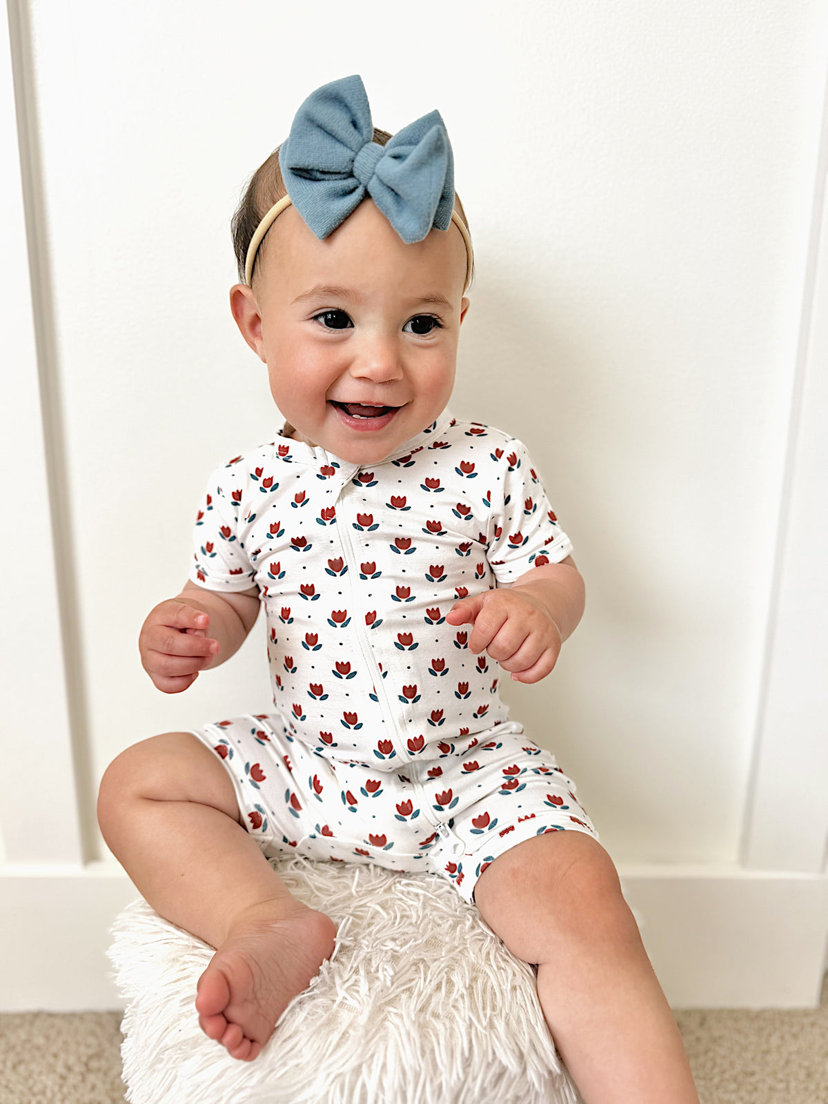 Little Joy Co. baby wearing a soft bamboo viscose shorty romper, smiling comfortably.