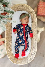 Baby zipper romper covered in reindeer print with bright red trim and fold-over feet