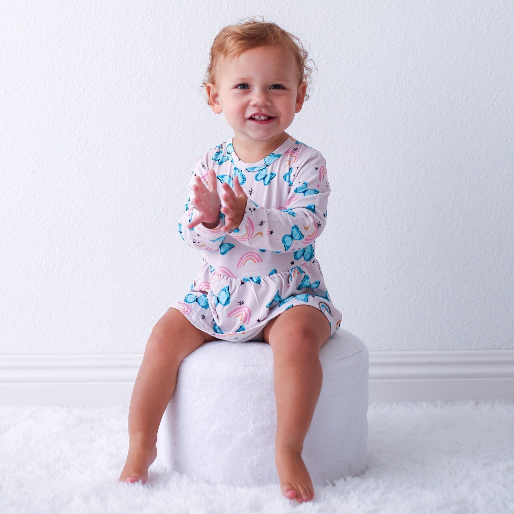 Baby bodysuit dress with retro butterfly print, long sleeves, and snap closure at the inseam
