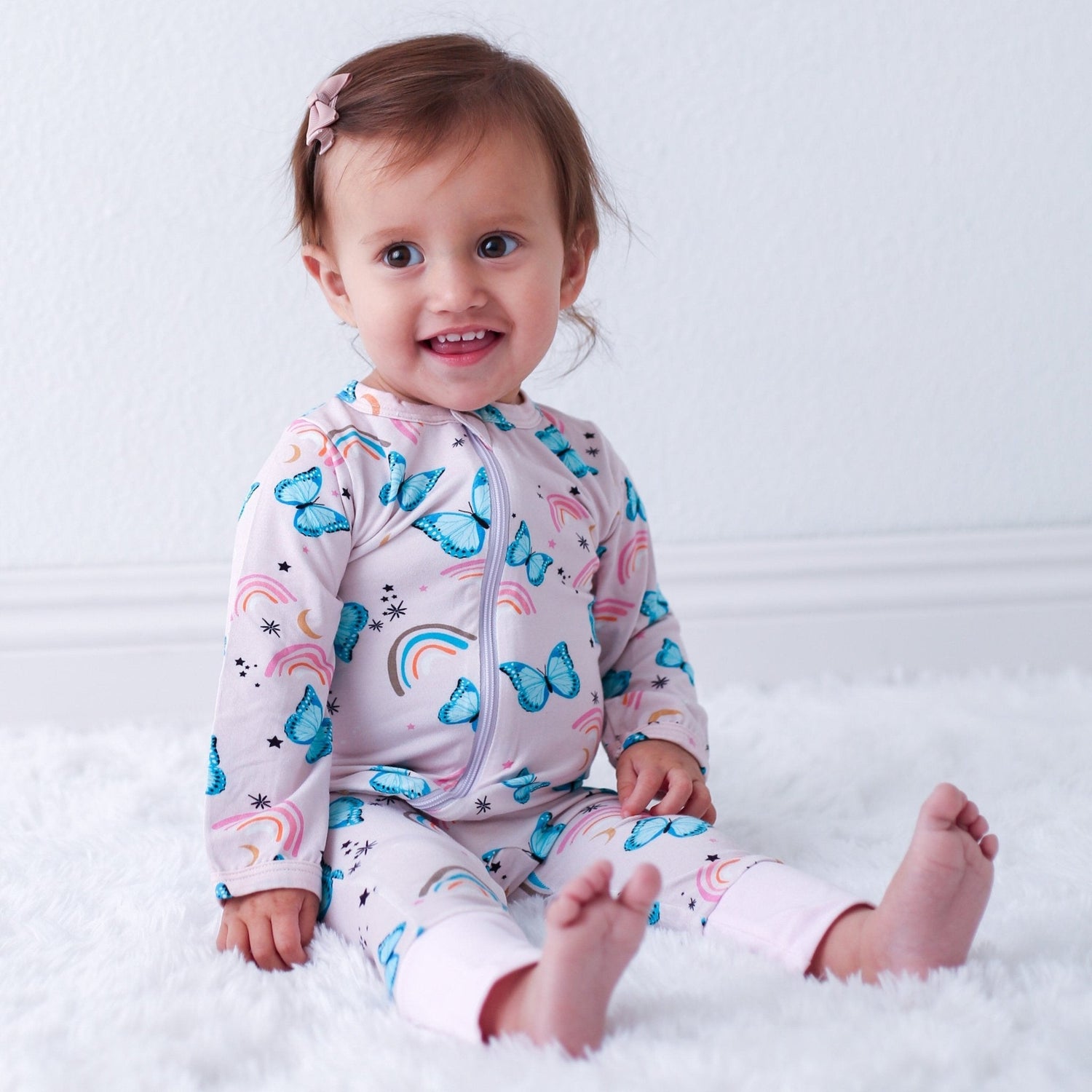 Baby romper in a retro butterfly print with a front zipper and cuffed ankles