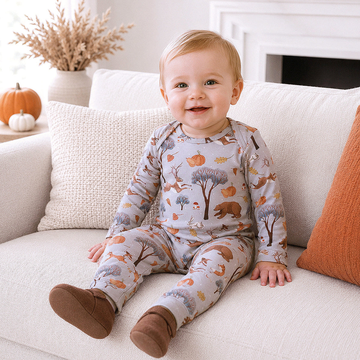 Baby romper in fall print with woodland animals, trees, and pumpkins, envelope neckline and snap bottom