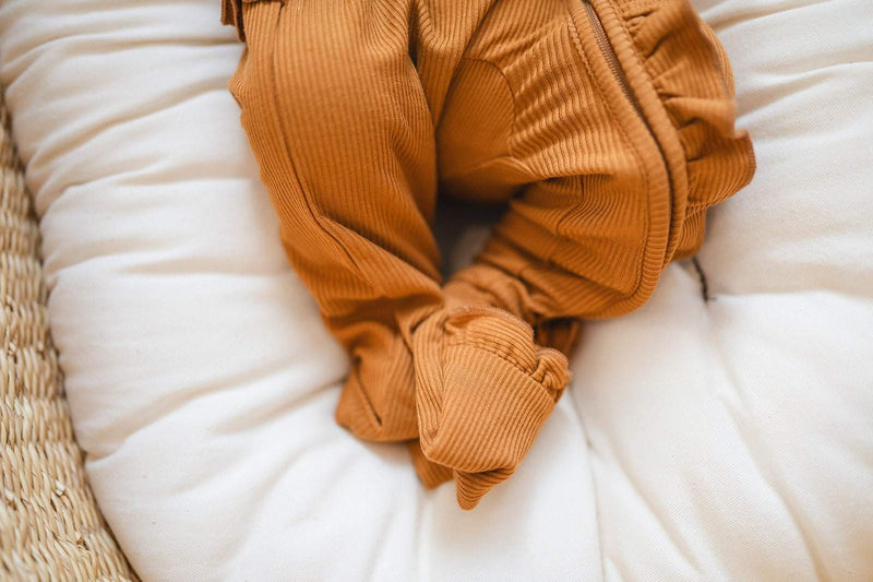 Caramel ribbed one-piece with zipper and ruffle details, fold-over hands and feet.