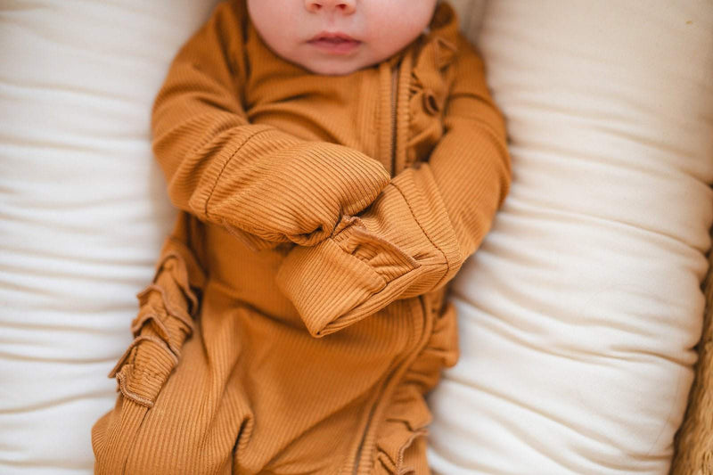 Ruffle Zipper One Piece in caramel ribbed fabric, featuring ruffle details and fold-over hands.