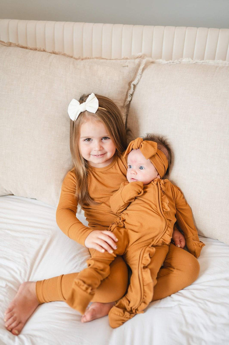 Ruffle Zipper One Piece in caramel ribbed fabric on two young children, featuring fold-over hands and feet.