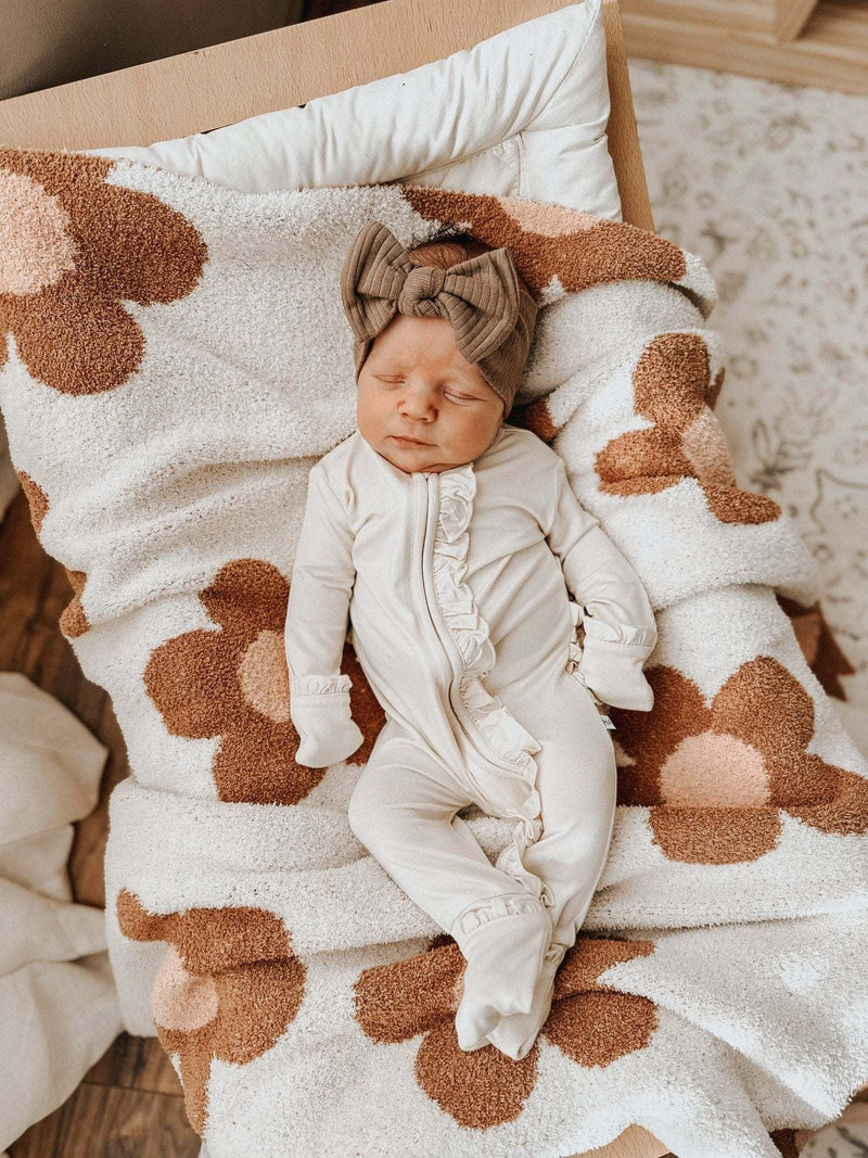 Cream ruffle zipper one piece for babies, made from soft bamboo viscose, with fold-over cuffs and two-way zipper.
