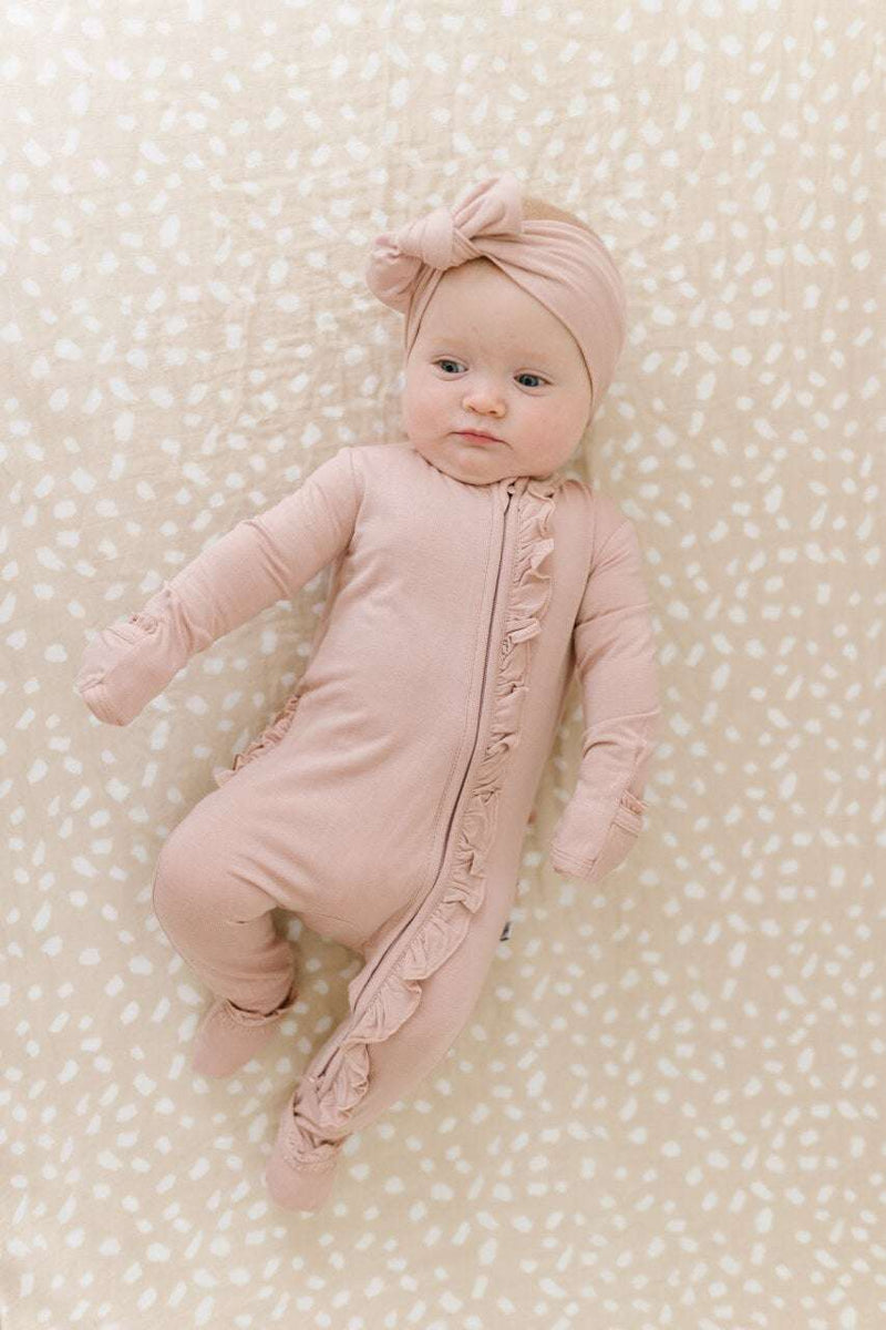 Dusty pink ruffle zipper one-piece with bamboo viscose fabric and fold-over cuffs for babies.