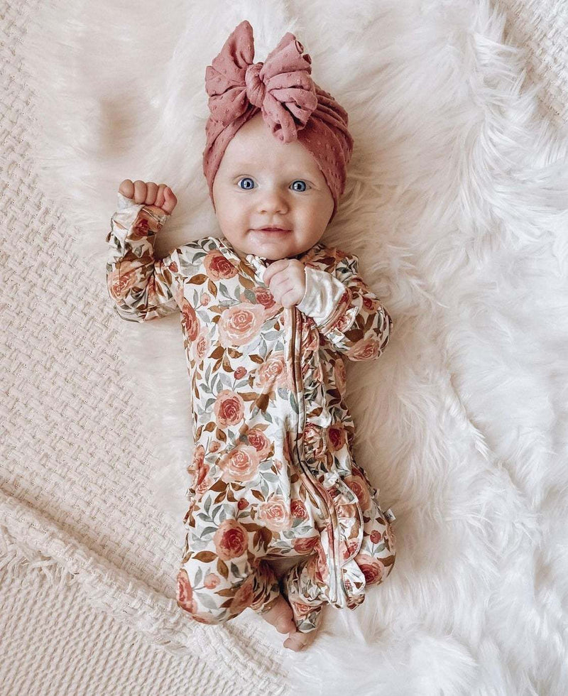 Dusty pink floral ruffle zipper one piece for babies, made from soft bamboo viscose with fold-over cuffs.