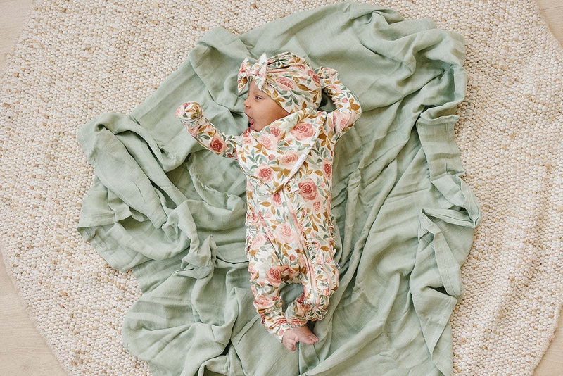 Dusty pink floral ruffle zipper one piece for baby, made from soft bamboo viscose, with fold over cuffs and two-way zipper.