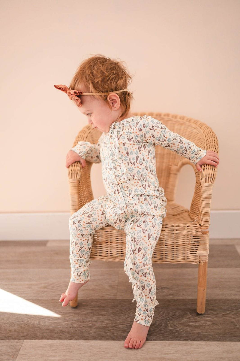 Ruffle Zipper One Piece baby pajamas in La La Floral design with 2-way zipper, fold-over features, and ruffle details, made from ultra-soft viscose bamboo.