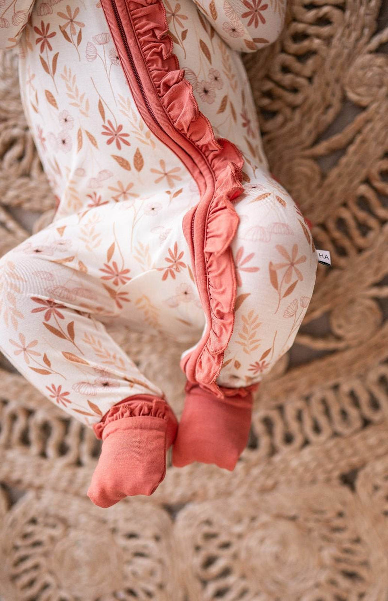 Wildflower bamboo baby romper with zipper and ruffle details.