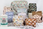 All-in-one cloth diaper starter bundle in a gender-neutral safari print with diapers and wet bags.