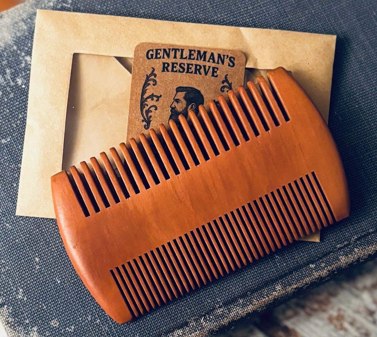 Sandalwood beard comb with dual-sided teeth, wider spacing on one side and finer teeth on the other