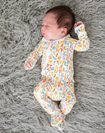 Baby footie pajamas with a scribble print and a two-way zipper running from neck to feet.