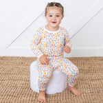 Long sleeve baby pajama set with a whimsical alphabet scribbles print on top and pants.