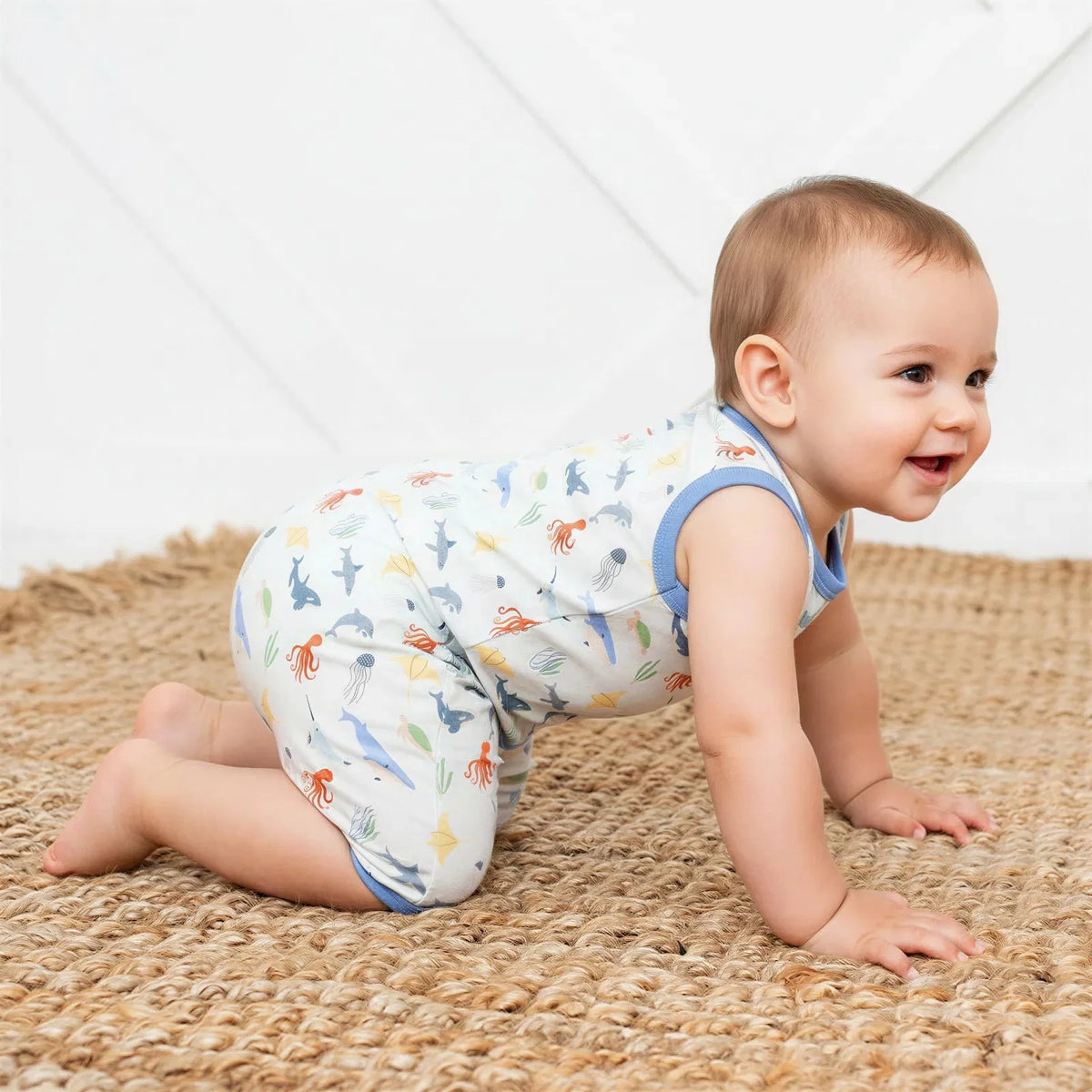 Sleeveless baby shortall romper in a sea life print with snap closures at the shoulders and legs