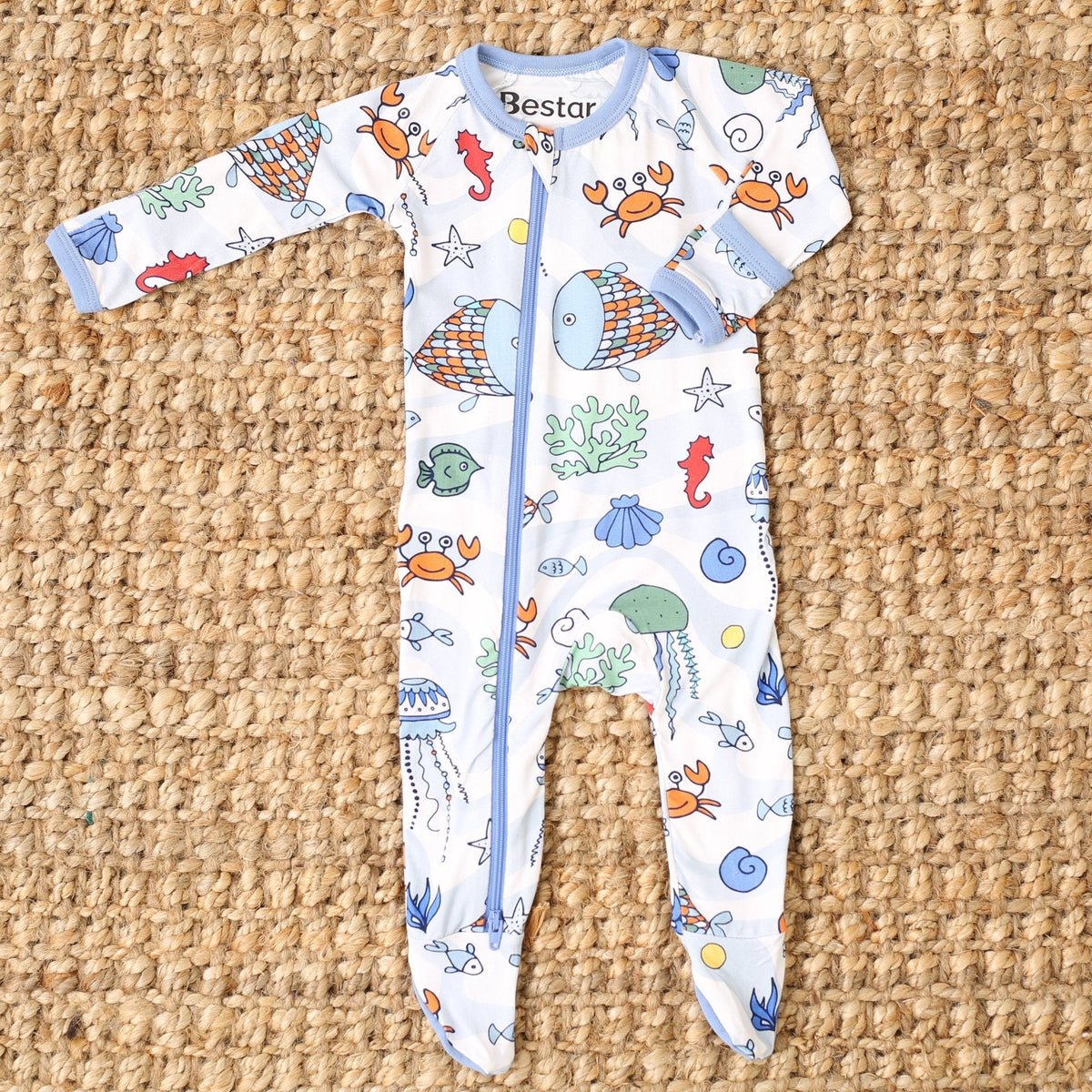 Baby footie pajamas in a sea life swirl print with blue and orange creatures and a full-length zipper.