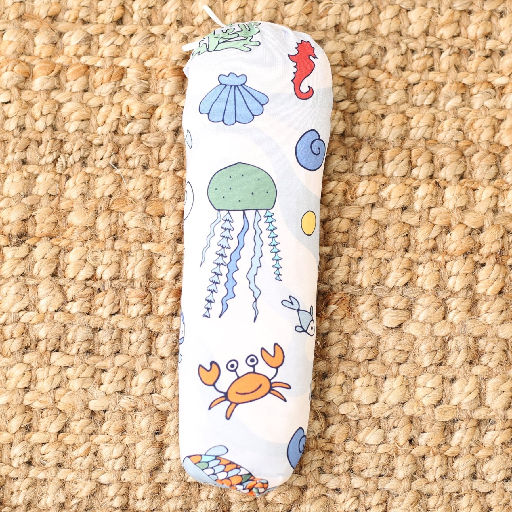 Bamboo baby swaddle blanket with a blue sea swirls and fish print, laid flat as a square.