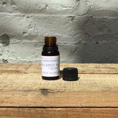 Seasonal Spring Relief essential oil blend bottle on wood surface.