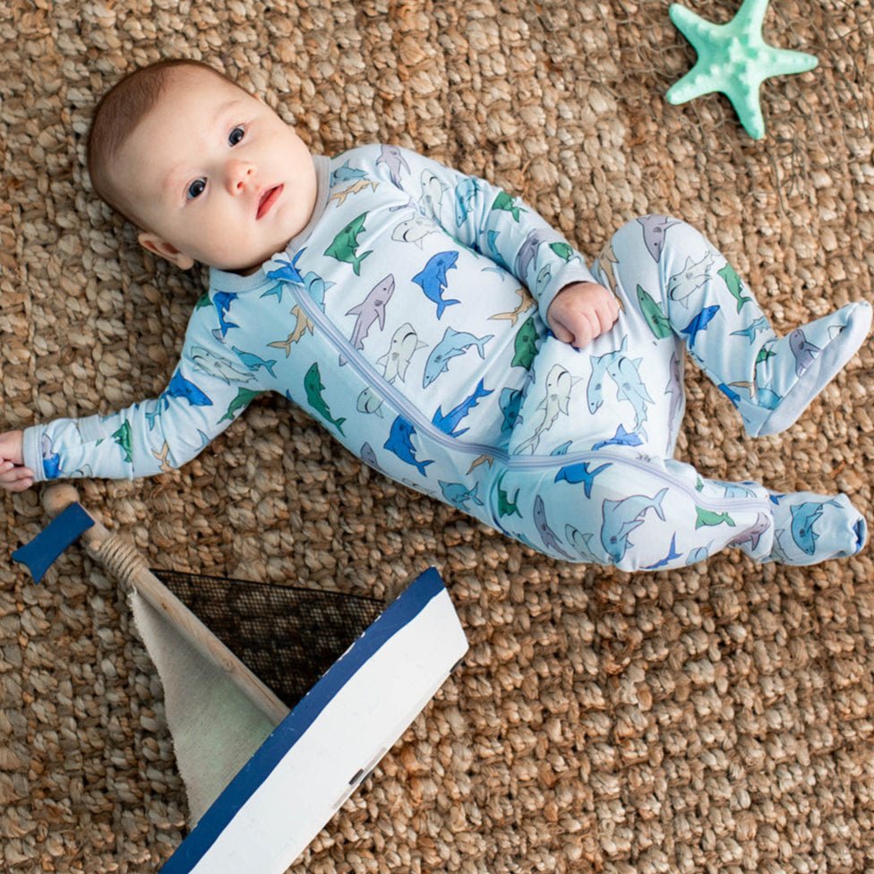 Baby footie pajamas with an allover shark print and a full-length front zipper.