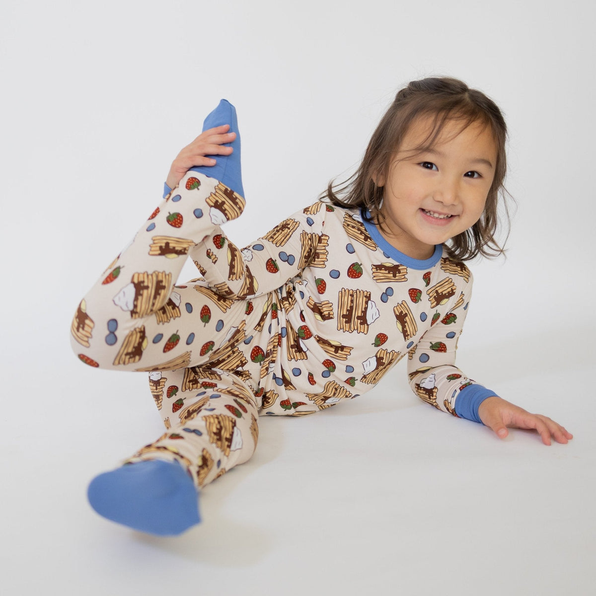Toddler two-piece pajama set in pancake print with blueberries and strawberries, featuring fold-over feet.