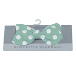 Jade green baby headband with white polka dot pattern and a bow tie detail