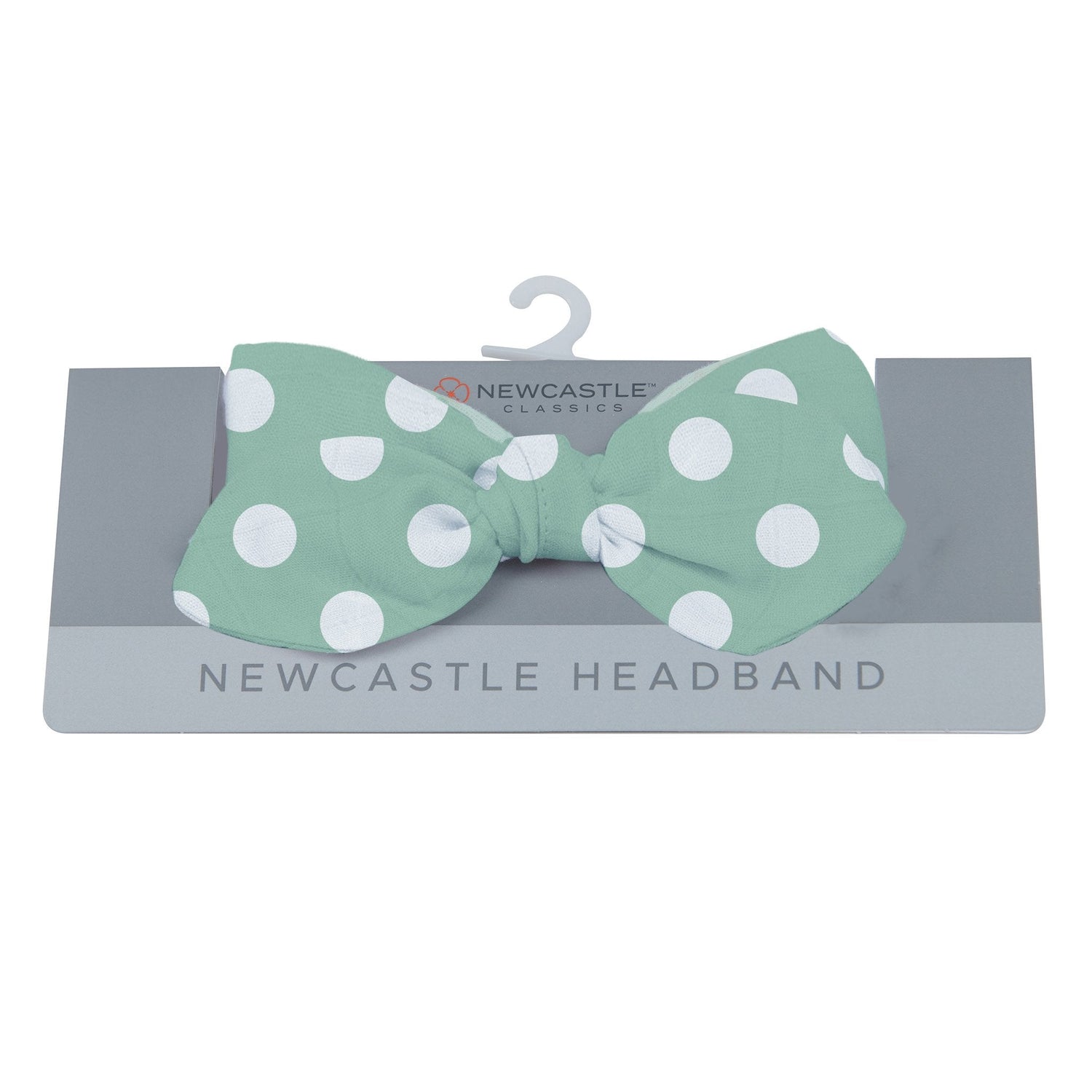 Jade green baby headband with white polka dot pattern and a bow tie detail