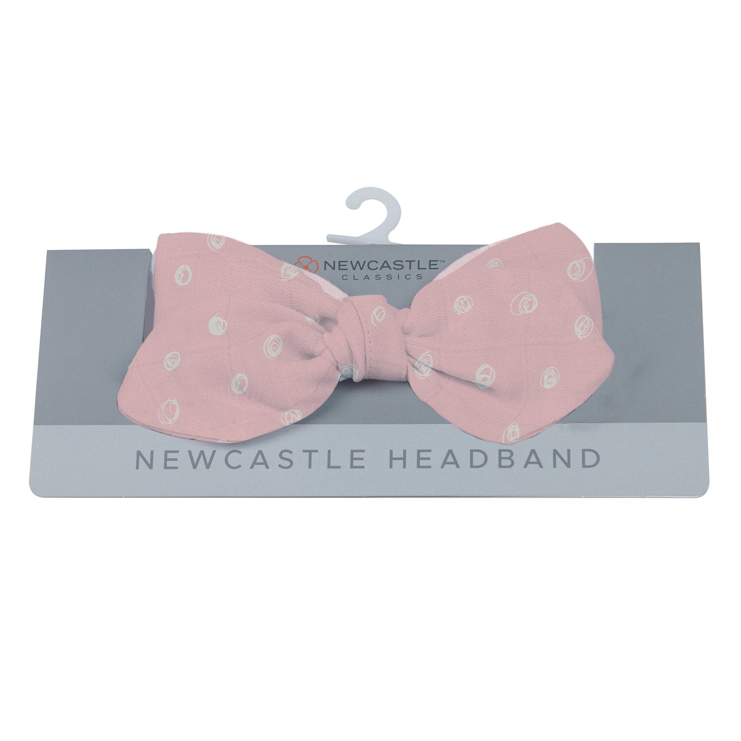 Baby headband in pink with white polka dot pattern and a bow tie detail
