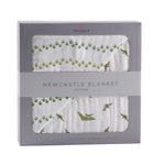 Cotton muslin baby blanket with dinosaur feet and pteranodon print in soft muted tones