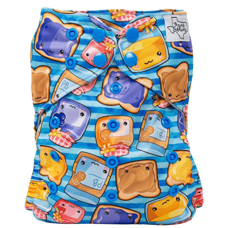 Slim Fit Pocket Cloth Diaper with colorful food-themed print and adjustable blue snaps.