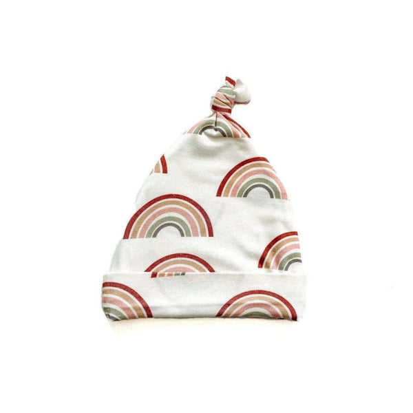 Newborn baby hat with a top knot in a soft neutral rainbow print.