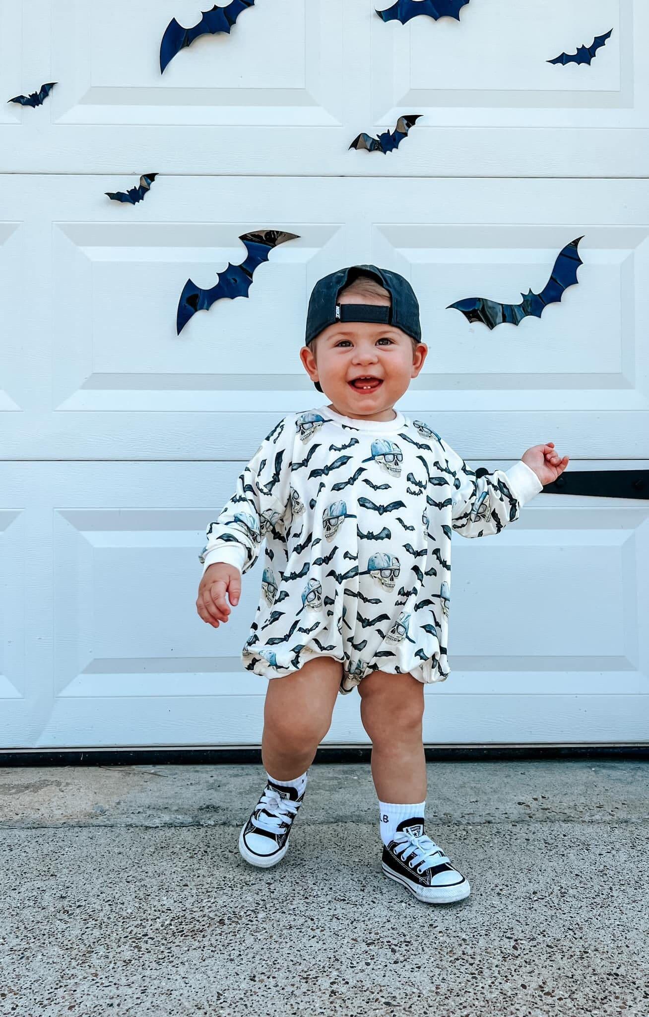 Baby bubble romper printed with a Spooky Bro Halloween design, also shown as a matching crewneck sweatshirt.