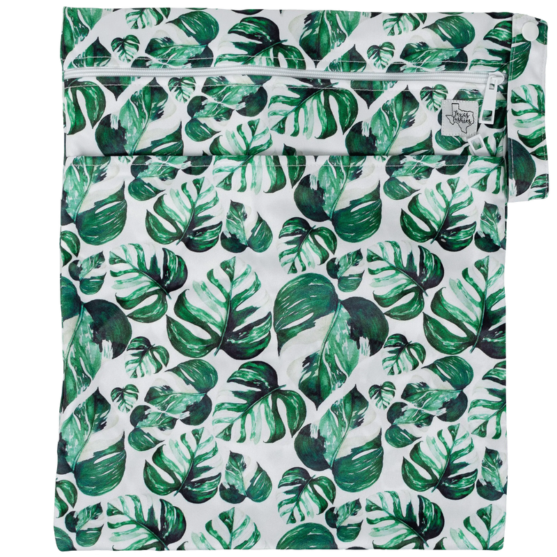 Texas Tushies Wet/Dry Bag with leafy pattern, two compartments, and strap.