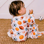 Baby footie pajamas with an all-over sports print and a full-length front zipper.