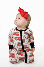 Baby zip-up bamboo pajamas with fold-over feet in a bold red firetruck print for infants.