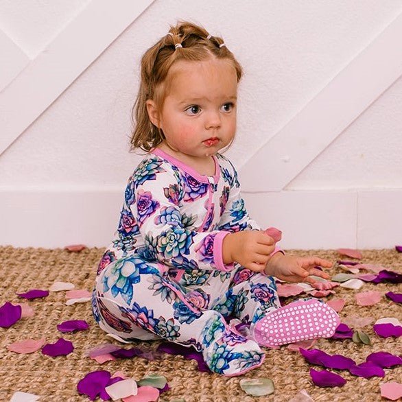 Baby footie pajamas with a green succulent print and a two-way front zipper.