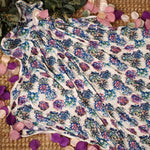 Swaddle blanket with pink and purple succulent print, spread flat to show the square shape.