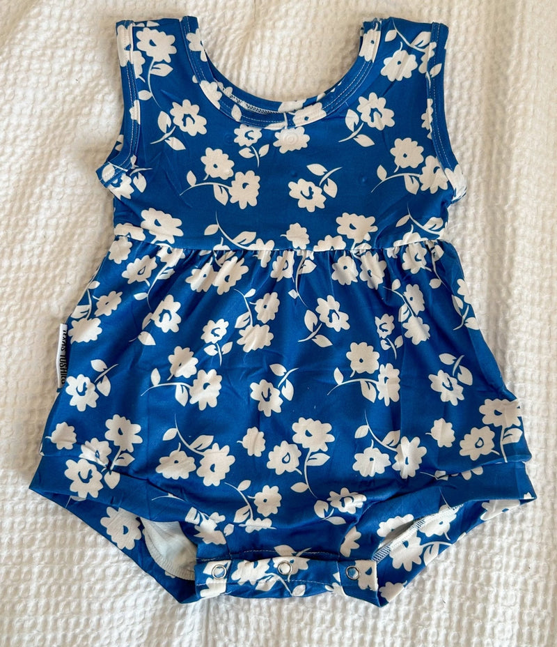 Blue summer boxy romper with white floral print, made of soft polyester, featuring snaps for easy diaper changes.