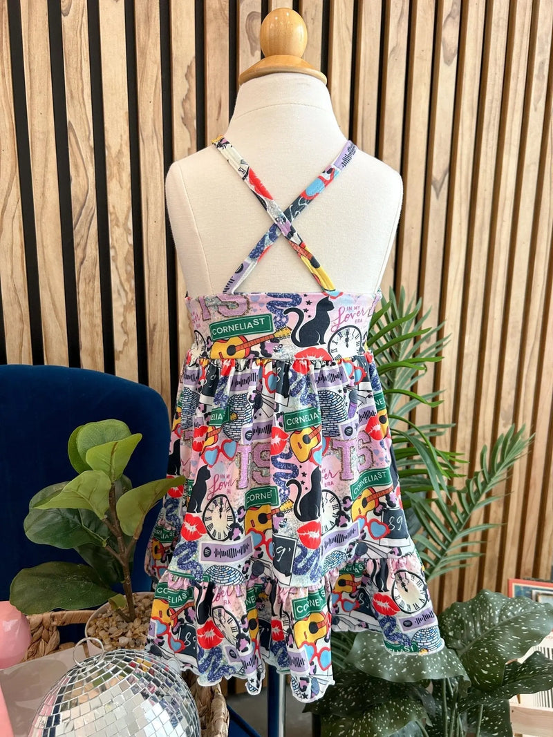 Summer Ruffle Dress with colorful patterns and crisscross straps displayed on a mannequin.