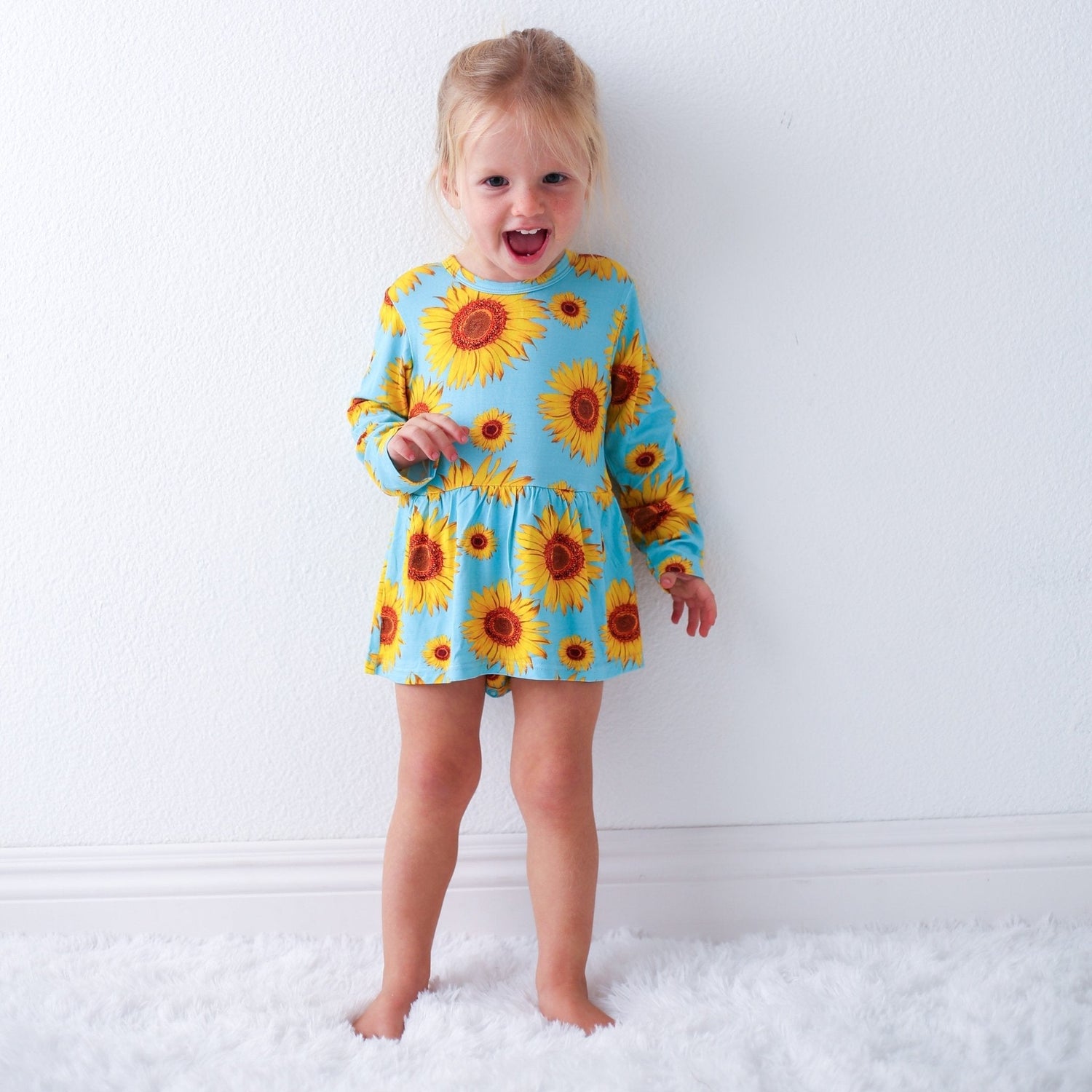 Bodysuit dress with sunflower print, long sleeves, and snap closure at the inseam