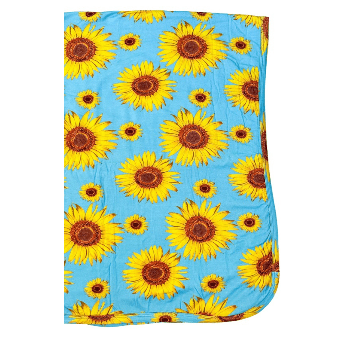 Baby swaddle blanket with a yellow sunflower pattern spread out flat