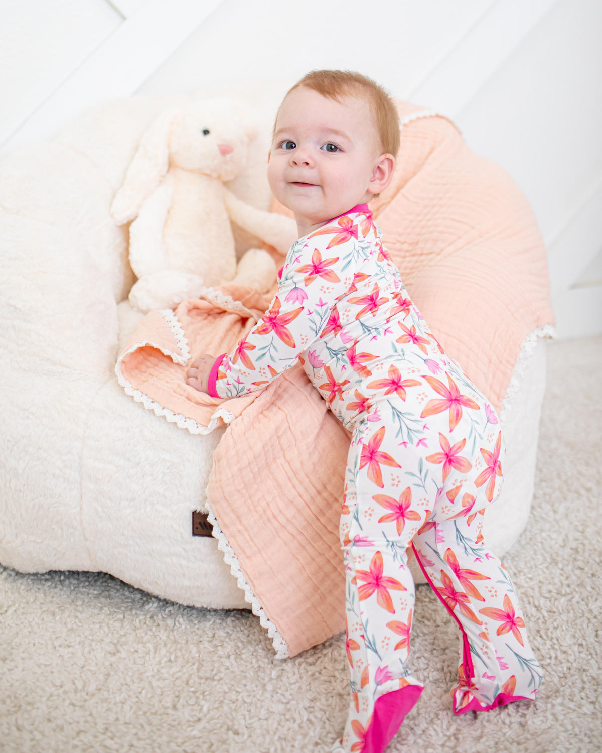 Baby footie pajamas in Sunset Leilani print with two-way zipper and covered feet
